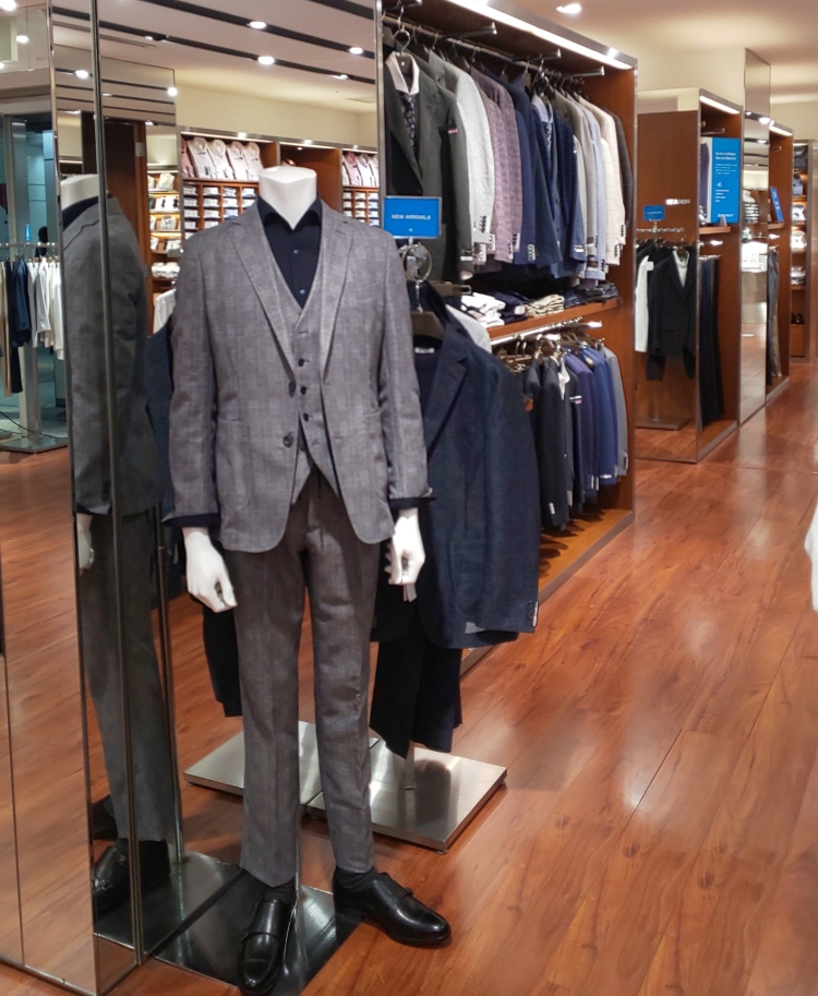新宿西の店内画像。グレー系3Pスーツを着用したマネキンが立っている。その奥にはたくさんのスーツが陳列されています。