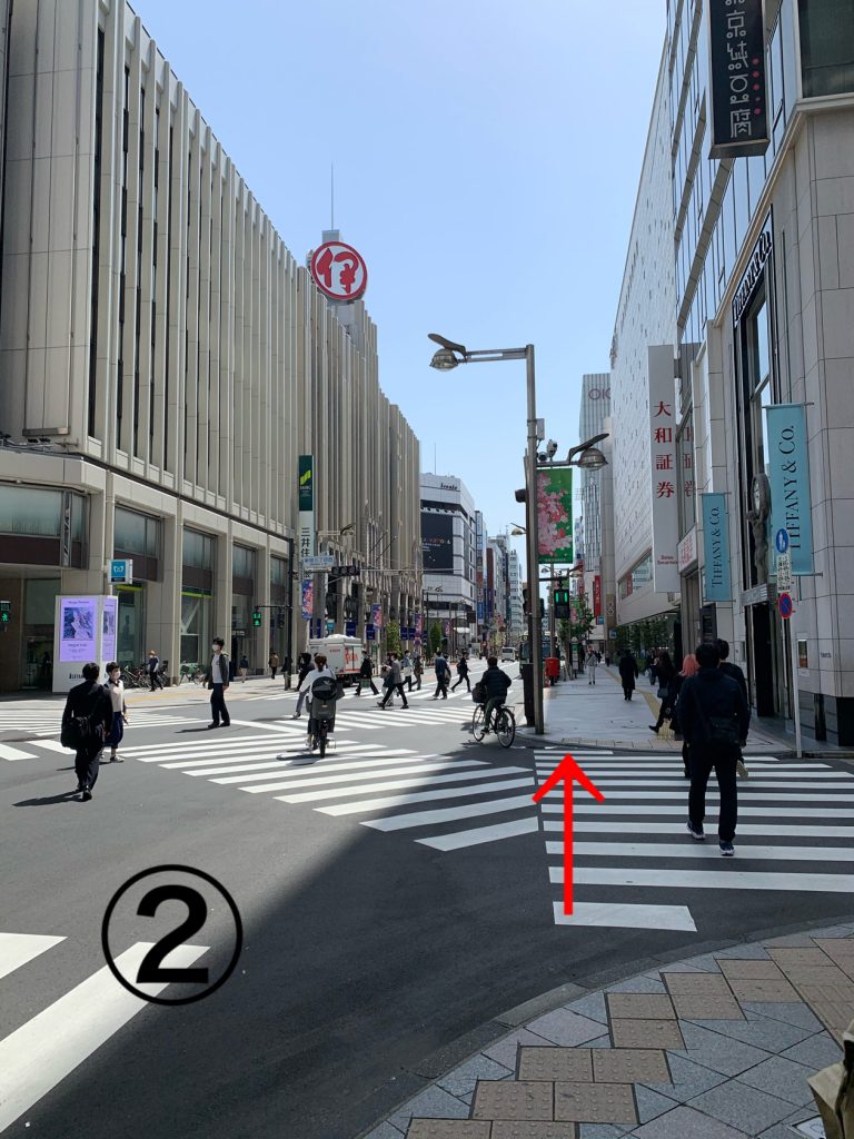 新宿駅近辺の画像。左手には、伊勢丹、右手にはマルイ本館が位置している。横断歩道を往来する人々が数人確認できます。
