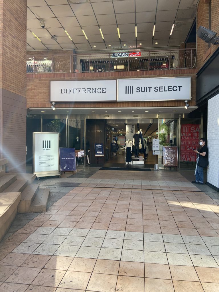 スーツセレクト横浜西の店頭画像。
店頭正面の画像。
ガラス張り、正面にマネキン人形2～3体が見える。difference、suit　select両店の看板が入口上に掲げられている。看板はいずれも白地に黒。向かって左側にセレクトのつい立て看板あり。全体的に煉瓦調。


画像に alt 属性が指定されていません。ファイル名: 666%E2%98%85%E5%BA%97%E8%88%97%E5%A4%96%E8%A6%B3%E2%91%A0-768x1024.jpg