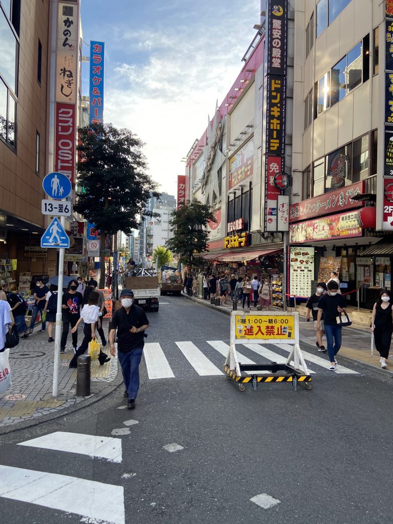 横浜駅近辺の道路画像。手前縦と横に横断歩道。数人が行き来。横断歩道には、車両の進入禁止の立て看板。ドン・キホーテ、ねぎし、等の看板が見える。