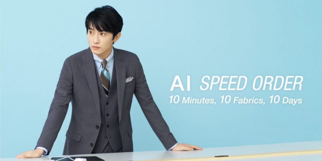 AI SPEED ORDERの画像。俳優の杉野遥亮さんがグレーのスーツとレジタルタイを着用