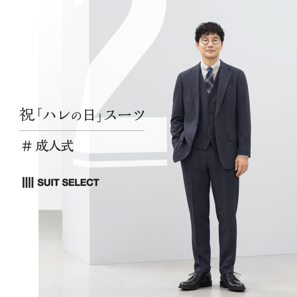 前原さんがネイビー系のスリーピーススーツスタイルで立っている。
淡いブラウン系(ベージュ)のシャツ、ネイビー系のネクタイを合わせている。
スーツ、シャツ、ネクタイ、全てチェックで揃えたコーディネート。シューズはブラックを合わせている。
右手はパンツのポケットに入れていて、こちらを穏やかな表情で見ている。
背景は淡いグレーで、スタイリッシュな印象のポスター画像。
文言は”祝「ハレの日」スーツ”。
その下に#成人式と記載されている。