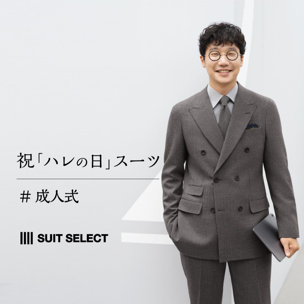 前原さんがチャコールグレーのダブルのスーツを着用して、こちらを見て微笑んでいる。同じくグレー系のシャツとネクタイを合わせている。
右手はパンツのポケットの中、左手にはipadのようなモバイルを持っている。膝から上の画像。白い壁面の部屋の一角のような場所。
晴れの日を意識したポスター画像。
文言は、”祝「ハレの日」スーツ”。
その文言の下に、＃成人式　と記載あり。
スーツセレクトの横型ロゴの記載もあり。
