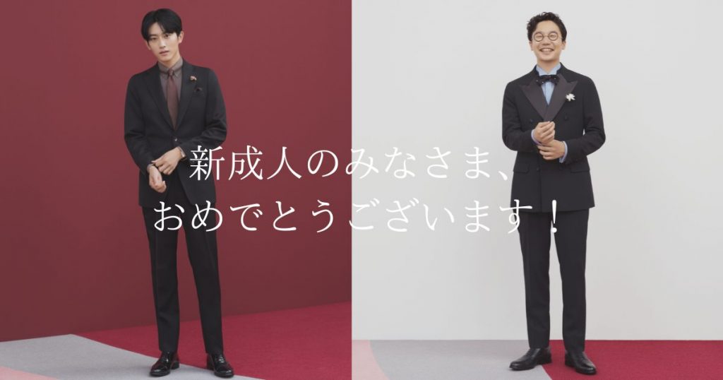 杉野さん、前原さんの２人が、正装して立っている。
向かって左側の杉野さんは、ブラックスーツにブラウン系のシャツとネクタイ。向かって右側の前原さんは同じくブラックのスーツ（衿部分の一部が異素材）に淡いブルー系のシャツと、黒っぽいボウタイスタイル。
成人のお祝いのポスター風。
文言”新成人のみなさま、おめでとうございます”
お祝いに相応しく、バックは紅白。