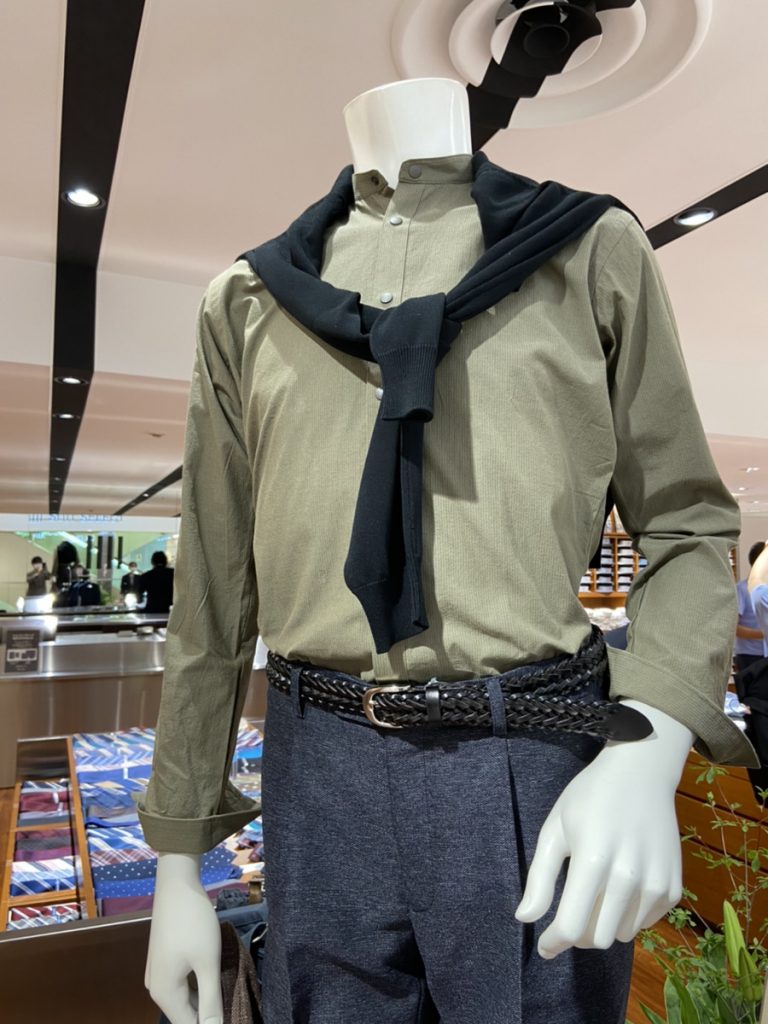 津田沼ビート　店内マネキン
カーキ色のシャツ、グレー系パンツ着用のメンズスタイルマネキン。肩からブラック系のニットを掛けている。