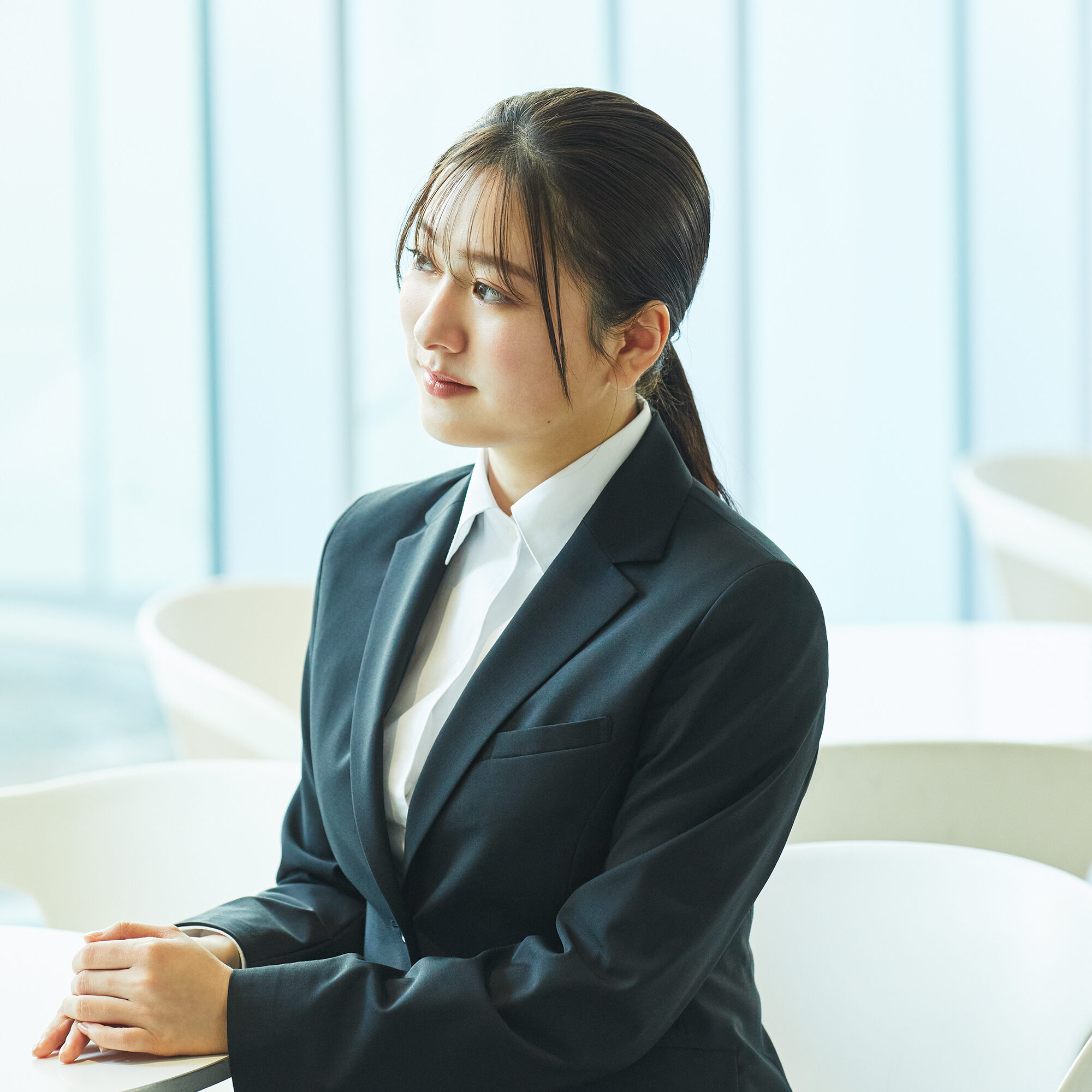 インターン・就活のイメージ写真。
黒いスーツの女性が神妙な面持ちでテーブルに座っている様子。