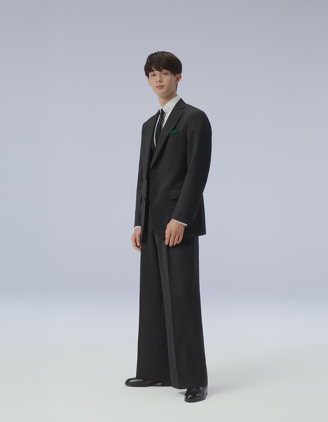 黒のスリーピースのワイドパンツスーツを斜めから見たモデル